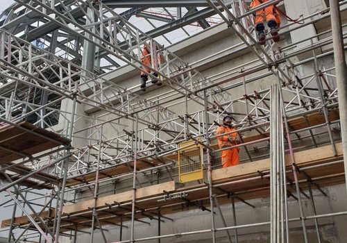 3 workers putting up scaffolding