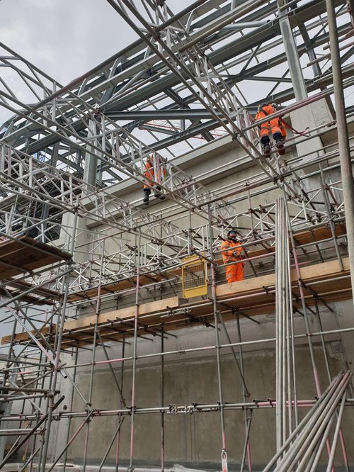 3 workers putting up scaffolding